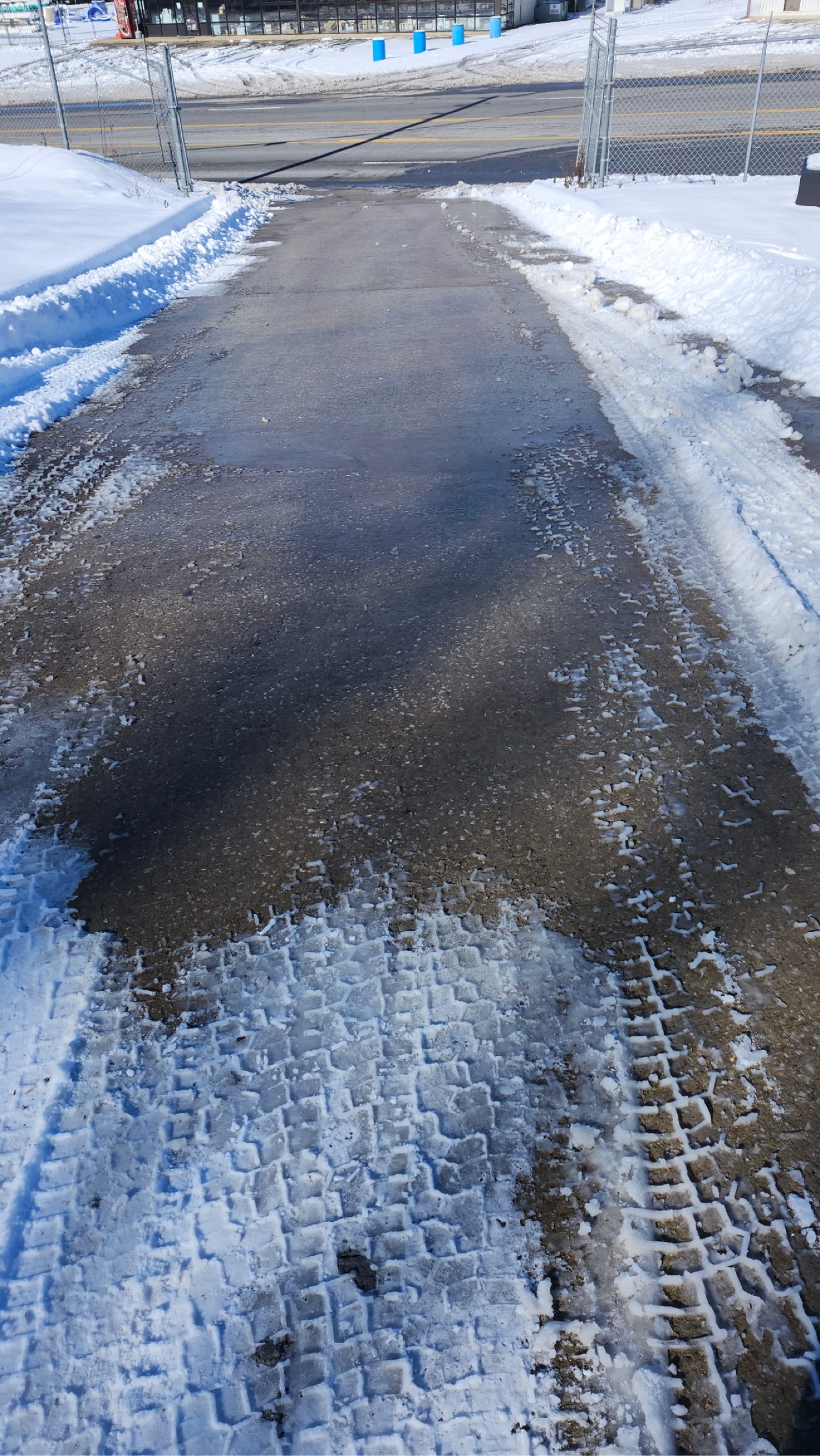 Cleared residential driveway with deep snow piled along both sides